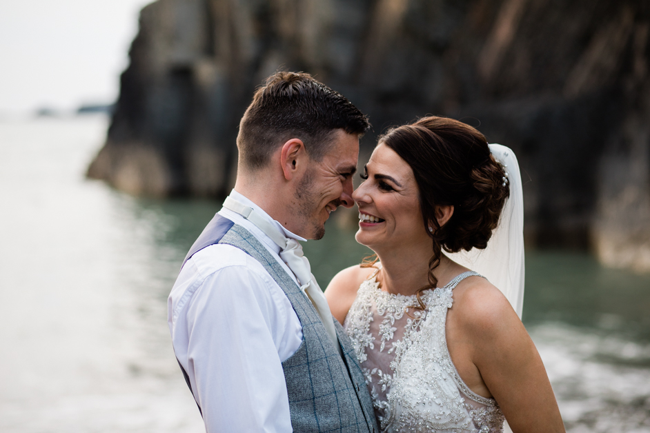 wedding couple looking into eachothers eyes, unposed, in love, happy, secret beach at the cliff hotel and spa