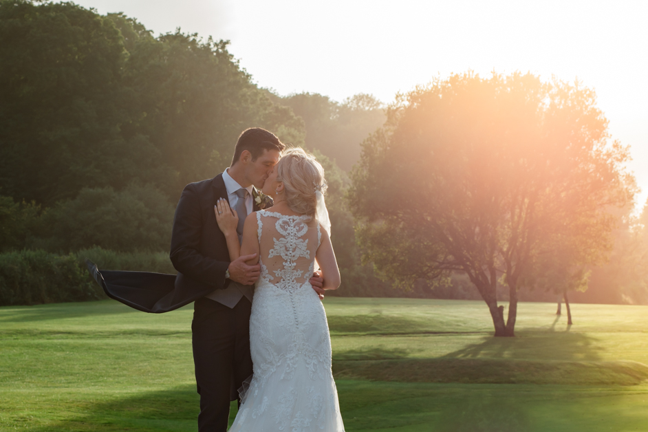 Sunset wedding photos, kissing at trefloyne manor, comfortable infront of the camera, lens flare,