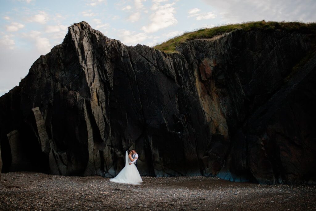 wedding couple with rock face behind, 