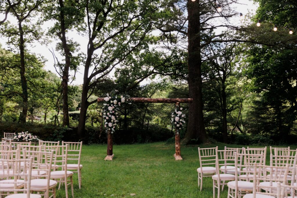 outdoor ceremony space, woodland ceremony, flowers on archway, 
