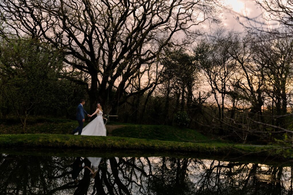 wedding couple walking along a lake, 
sunset, gellifawr ponds,
