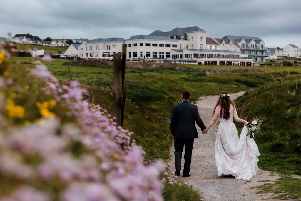 The cliff hotel and spa, Wedding couple walking back to the cliff hotel and spa, Thrift flowers in the foreground on wedding couple walking, 