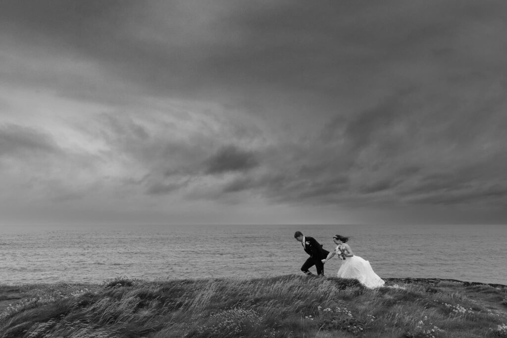 Wedding couple running in the rain, Wedding couple with seascape in the rain, 