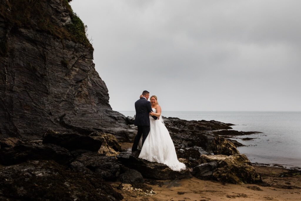aberporth. aberporth in the rain, wedding couple standing on the cliffs, wedding couple in the rain, west wales elopement,